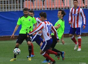Carlos Ramos intenta conducir el balón ante dos jugadores del Huesca